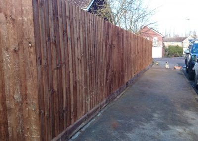Side pathway secured with tall timber fencing
