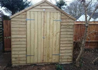 Timber garden shed installed within fenced outdoor space